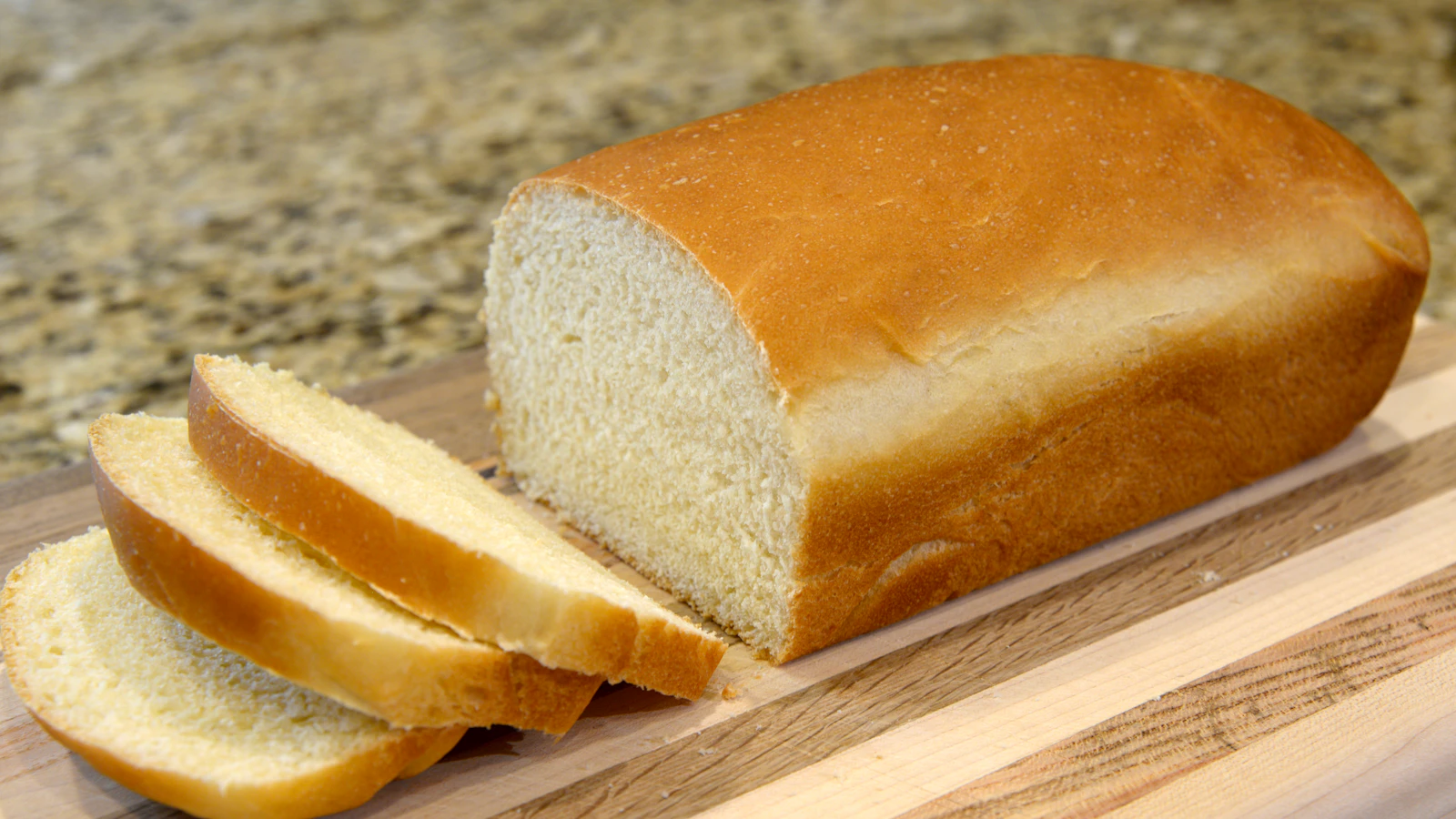 Vers brood in plakken op een houten snijplank.
