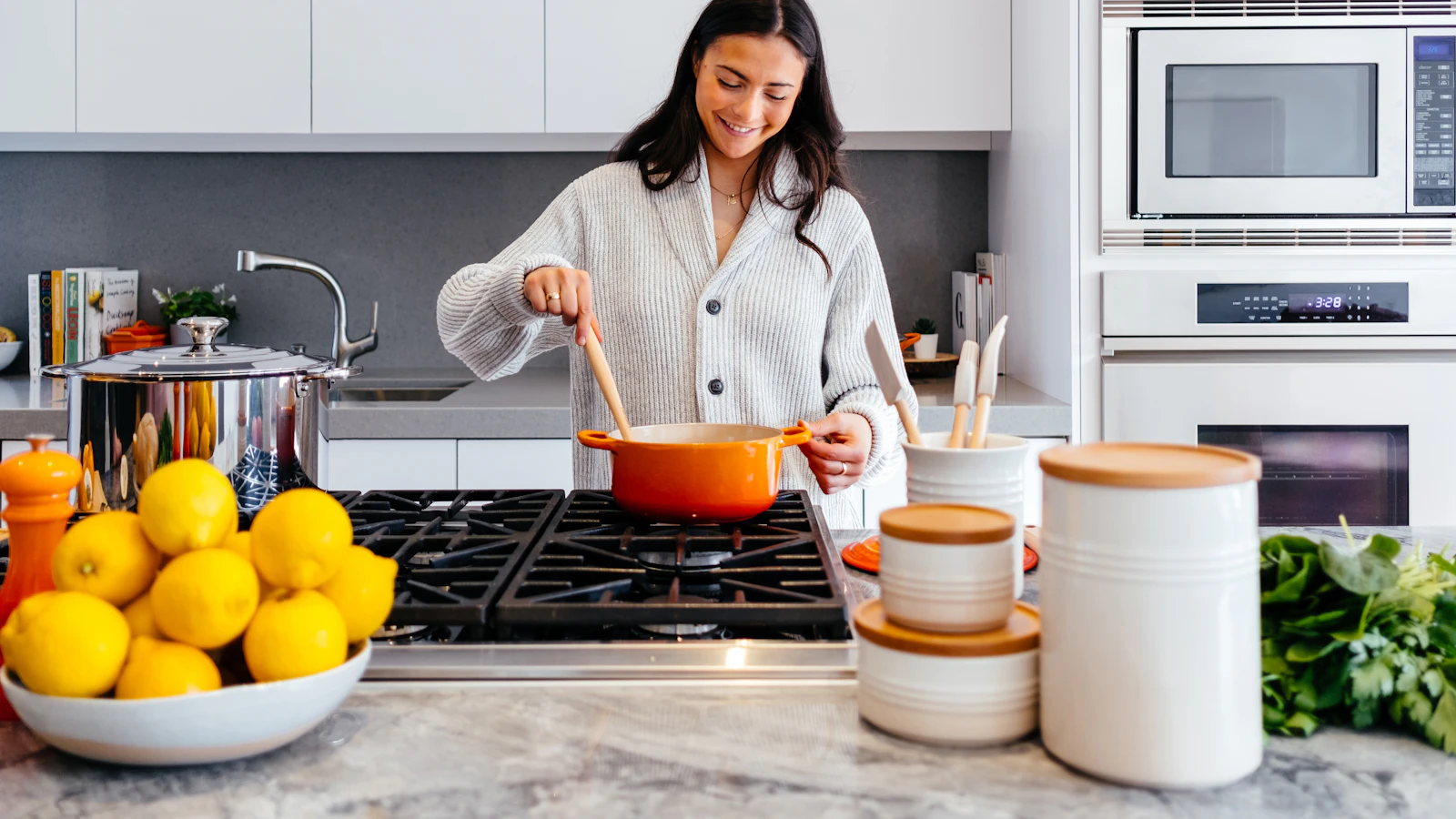 Vrouw bereidt een gezonde maaltijd met groente in de keuken.