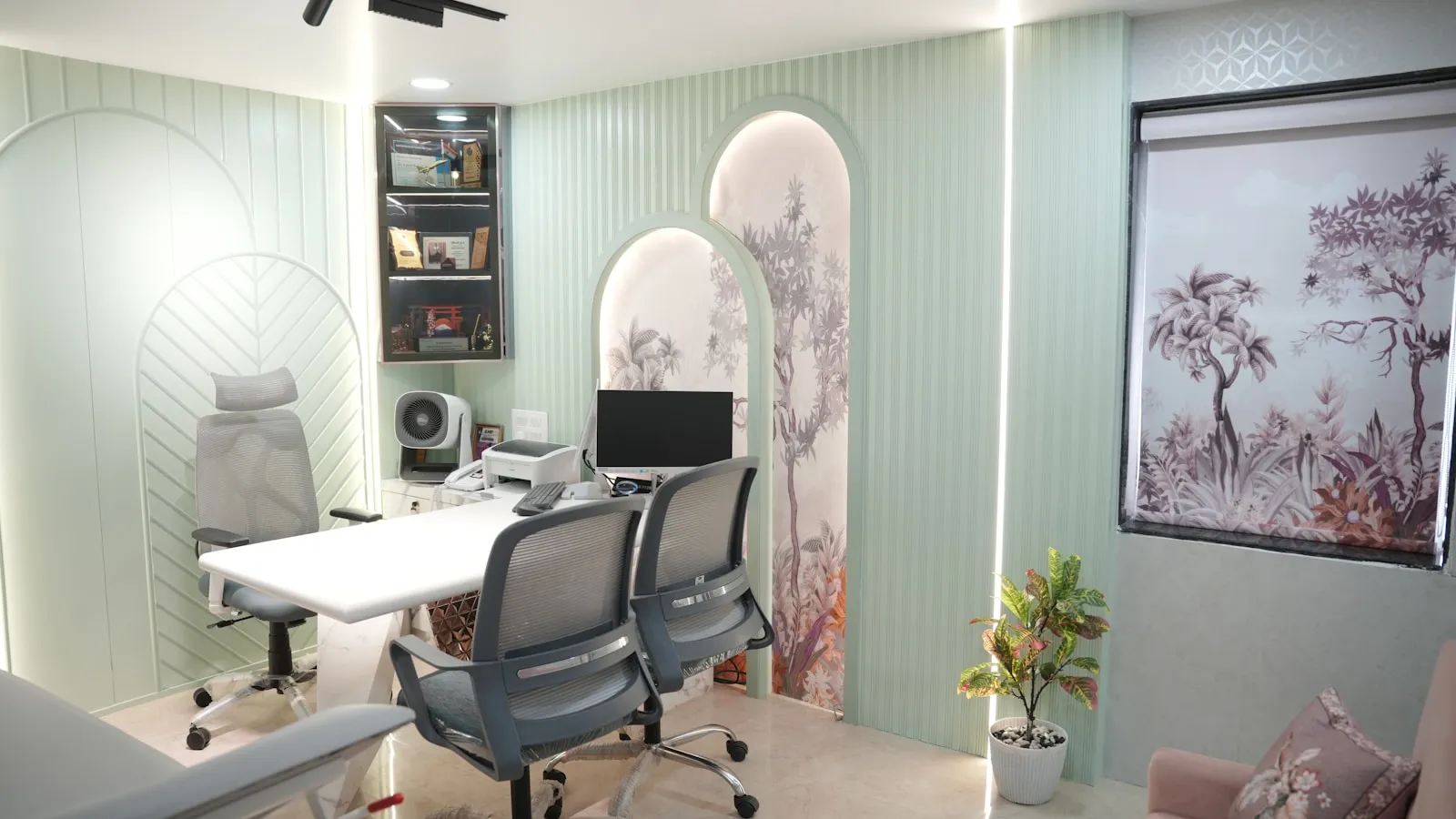 Lege spreekkamer met een bureau, twee stoelen en een computerscherm.