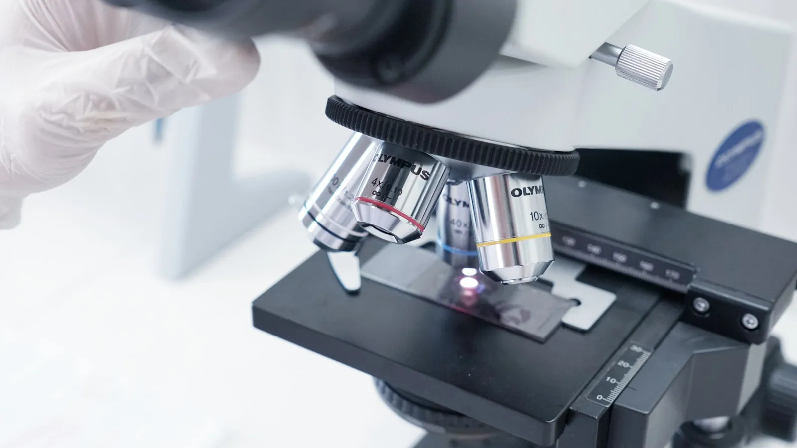 Close-up van een microscoop met objectglaasje in een laboratorium.