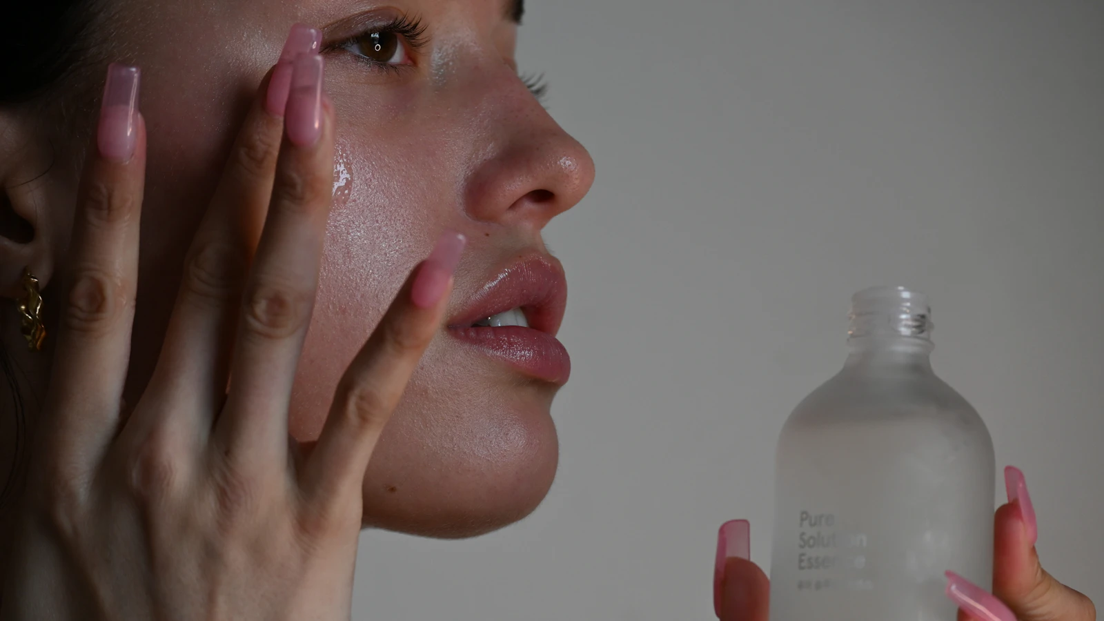 Vrouw bekijkt haar huid in de spiegel bij daglicht.