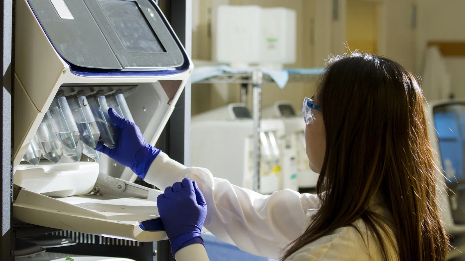 Laborant plaatst bloedbuisjes in een automatische celteller.