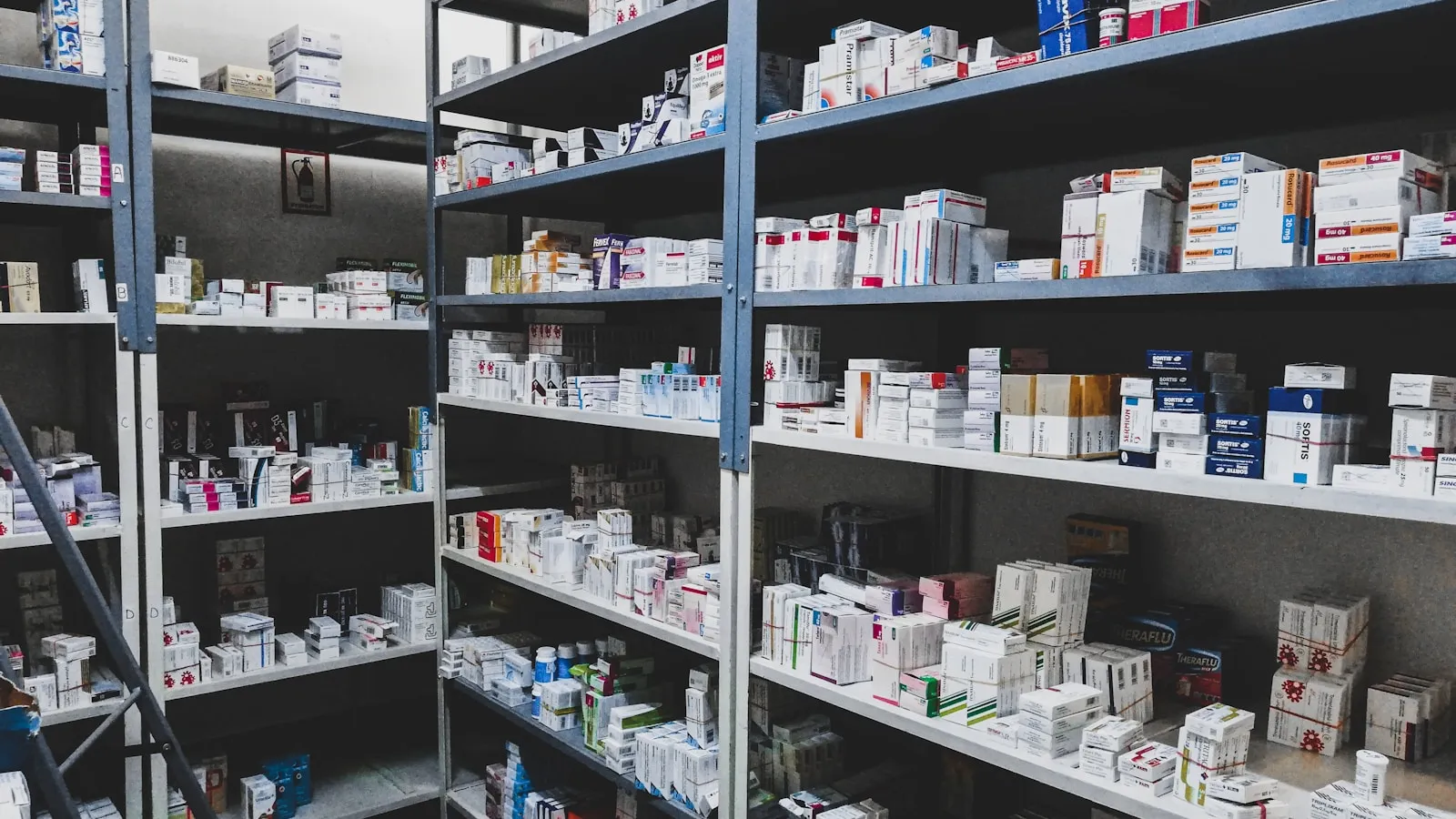 Apotheekschappen gevuld met dozen medicijnen.