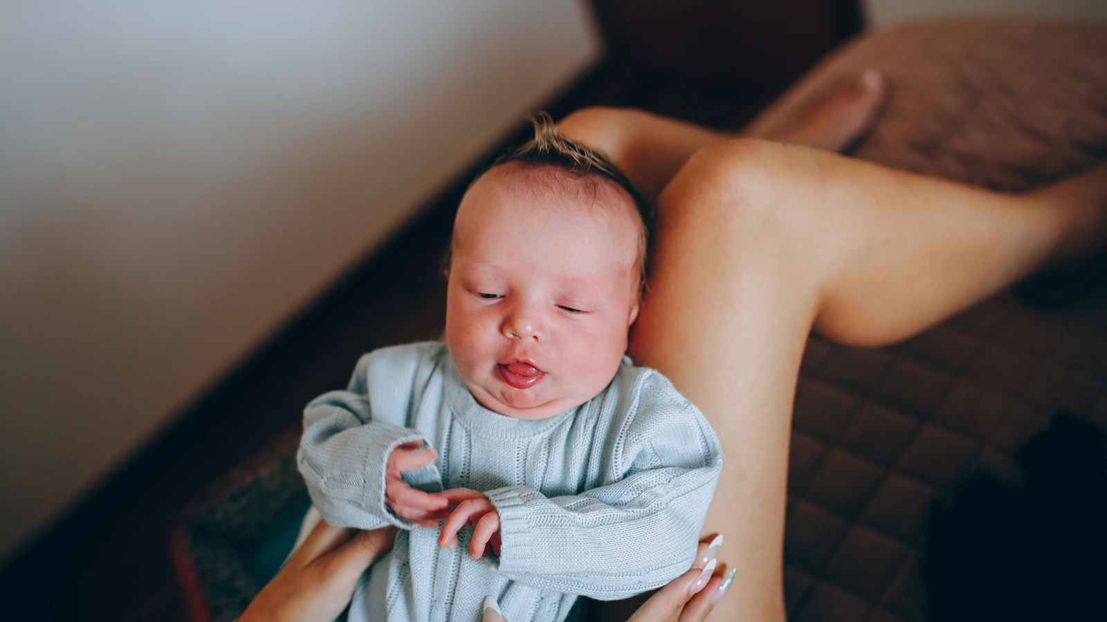 Moeder houdt haar baby rustig vast bij een raam.